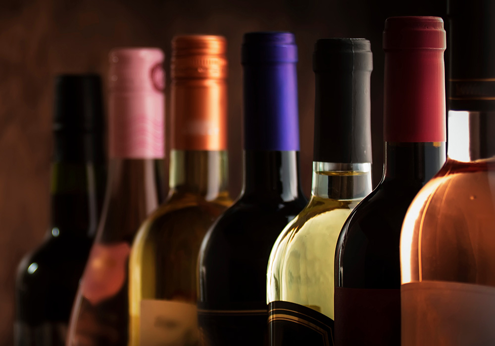 the top of seven premium wine bottles in a line